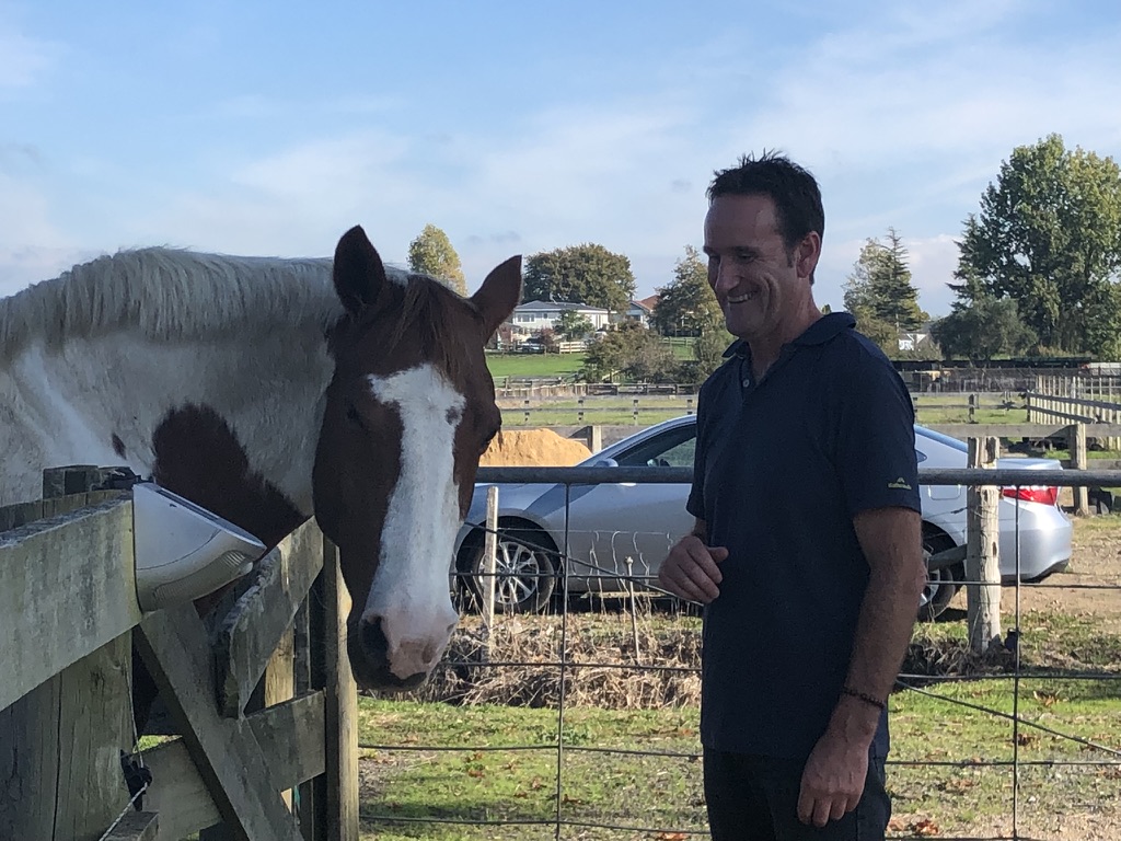 Steve Mullan with a horse at a Waikato farm on a sunny day